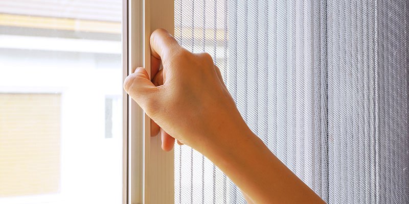 Pleated insect screen being opened on a door